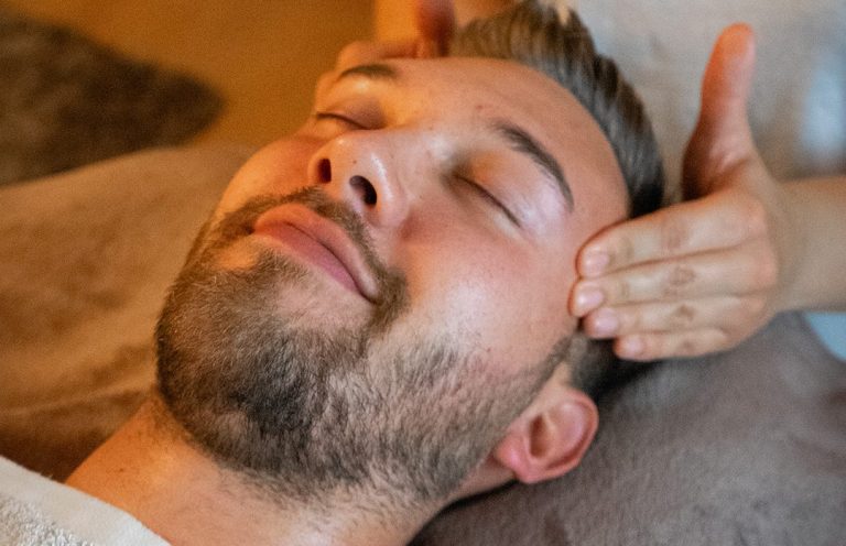 Mann erhält eine entspannende Gesichtsbehandlung.