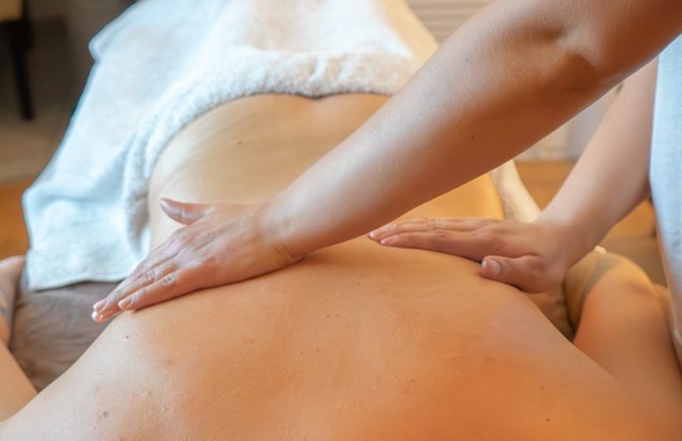 Massage wird auf dem Rücken einer liegenden Person angewendet.